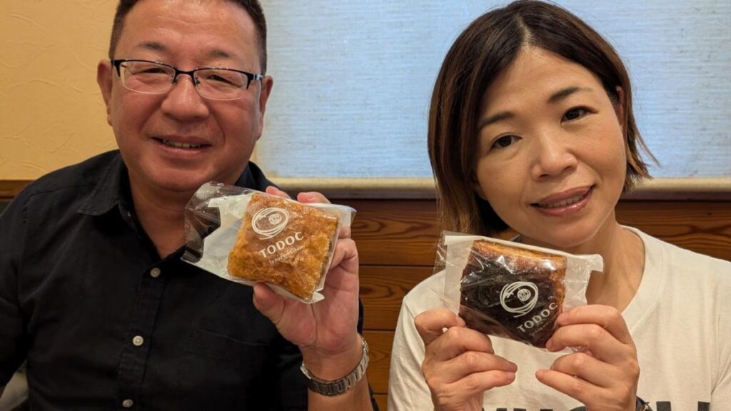 お菓子を持っている大久保佳代子と兄