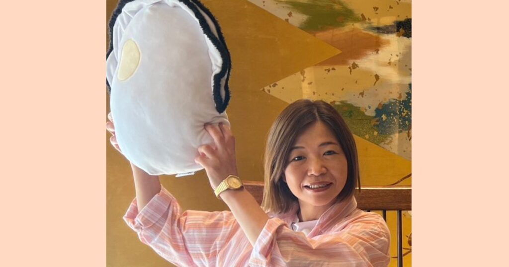屏風の前でカキのぬいぐるみを持つ大久保佳代子