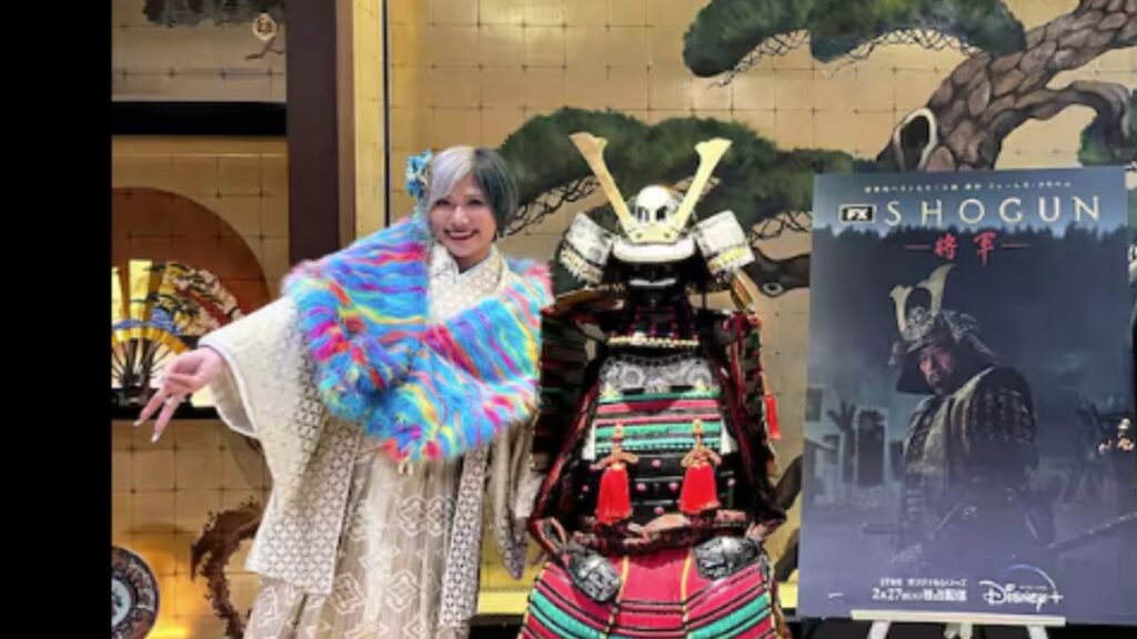 金屏風の前で甲冑とポーズするぱーてぃーちゃん信子