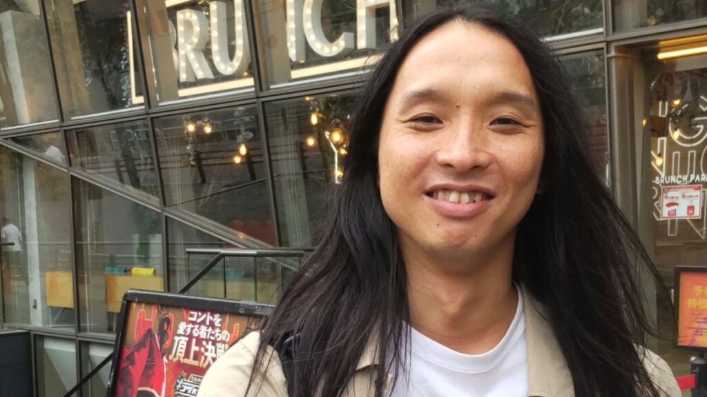 歯を出して笑う布川